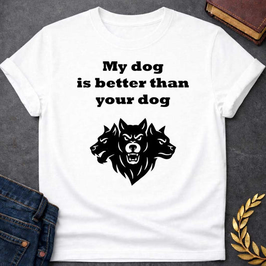 White T-shirt graphic in black and white featuring bold serif text reading "My dog is better than your dog" above a flat black silhouette illustration of Cerberus, the three-headed dog of the underworld, with the center head facing forward snarling and the two side heads in profile, in a humorous nod to Hades from Greek mythology, designed for a light-coloured shirt