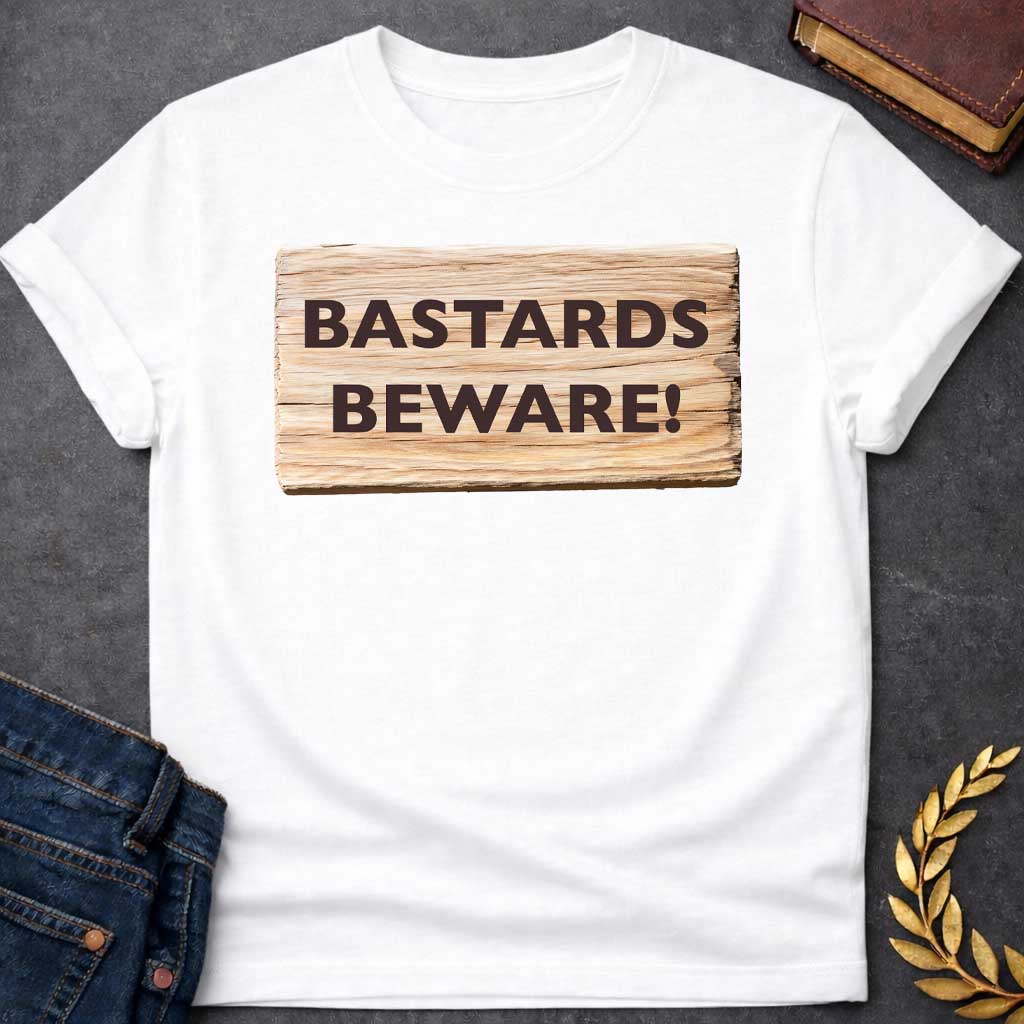 White T-shirt graphic featuring a realistic illustration of a weathered and splintered wooden plank sign with bold dark brown text reading "Bastards Beware!" in a humorous nod to Hera, the Greek Queen of the Gods, known for her jealous wrath toward Zeus's illegitimate children