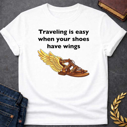 White T-shirt graphic featuring bold black text reading "Traveling is easy when your shoes have wings" above a detailed illustration of Hermes' winged sandal, depicted as a brown leather gladiator sandal with gold buckles and braided lacing, with a large golden wing extending from the ankle — a humorous reference to the talaria, the iconic flying sandals of Hermes, the Greek Messenger God
