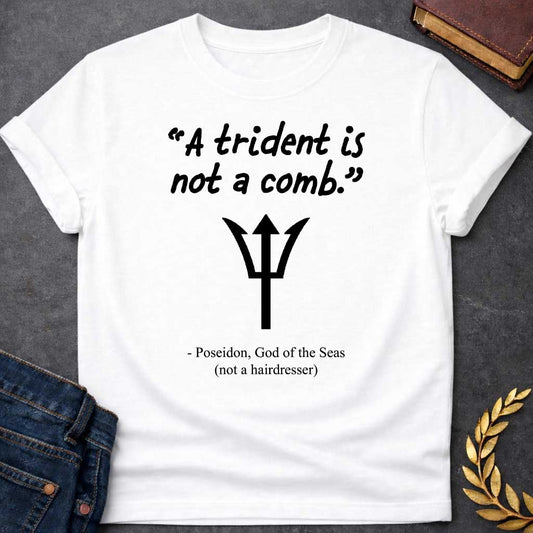 White T-shirt graphic featuring a black handwritten-style quote reading "A trident is not a comb." above a flat black trident symbol, with the humorous attribution below in clean serif text reading "- Poseidon, God of the Seas (not a hairdresser)