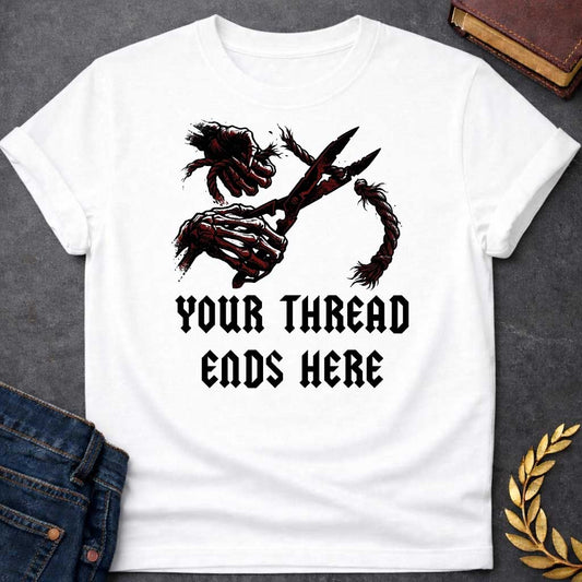 White T-shirt graphic in black, white, and dark red featuring a dark illustrated scene of two skeletal hands gripping large shears cutting through a thick fraying rope or thread, rendered in a gritty horror-influenced ink style with ink splatter details. Bold heavy metal-style blackletter text below reads "Your Thread Ends Here" — a dark and dramatic reference to Atropos, the eldest of the Moirai, the Greek Fate who cuts the thread of life
