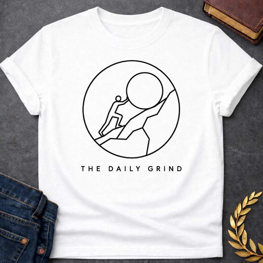 White T-Shirt with a minimalist black graphic design.  Inside a thin circle is a simple line-art illustration of a stick figure pushing a large boulder up a steep hill, representing the myth of Sisyphus. Below the circle, the text reads "THE DAILY GRIND" in a clean, sans-serif font.