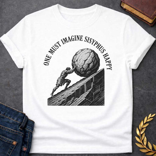 White T-Shirt with a high-contrast, black-and-white graphic design. The illustration features a woodcut-style depiction of Sisyphus straining to push a massive, craggy boulder up a steep, jagged mountainside. Arched in a bold, weathered serif font over the top of the illustration is the text "ONE MUST IMAGINE SISYPHUS HAPPY,"