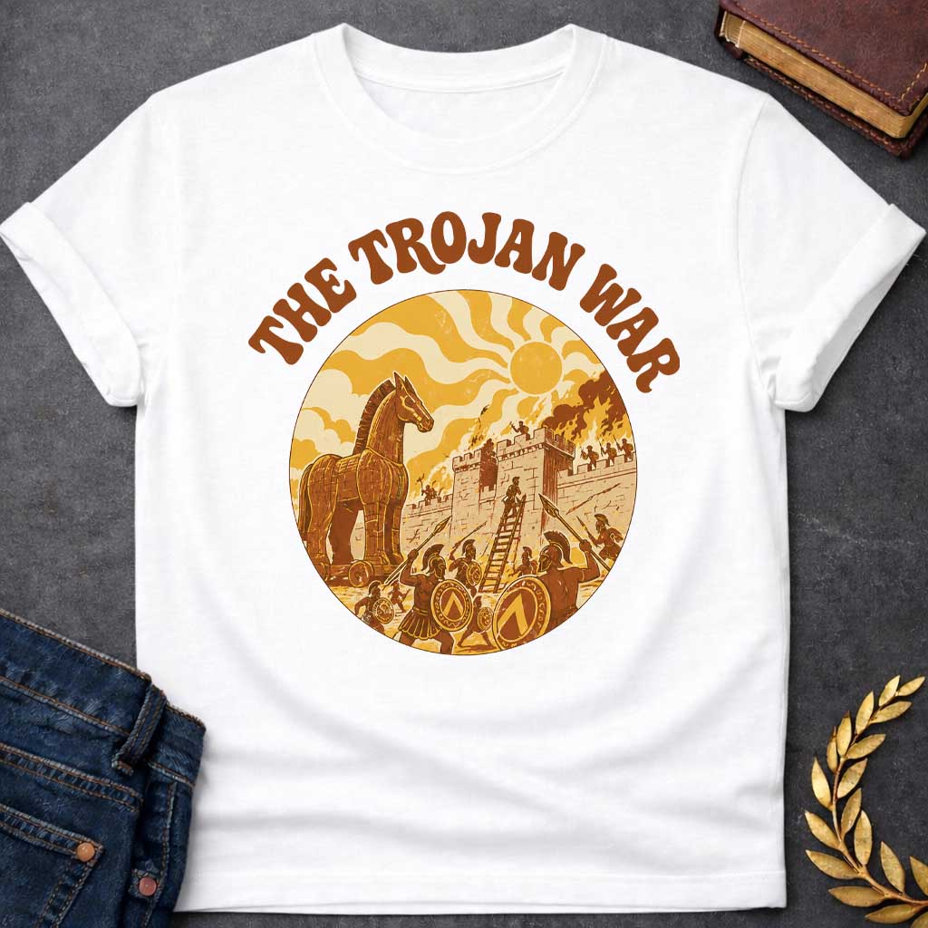 White T-shirt featuring bold groovy 1970s-style arched brown text reading "The Trojan War" above a circular vintage illustration depicting the siege of Troy — the Trojan Horse stands to the left while Greek warriors with Spartan shields and spears storm the burning walls of Troy using a ladder, under a stylized wavy sun, rendered in a warm retro palette of golden yellow, burnt orange, and brown tones