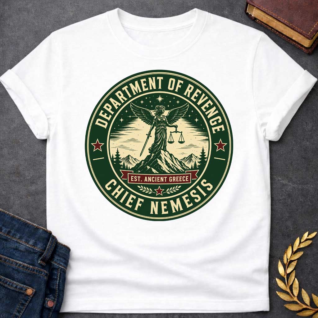 White T-Shirt with an Official seal-style circular design in forest green, cream, and burgundy red. Features Nemesis, the winged Greek goddess, standing on a mountain peak holding scales of justice and a sword. Starry night sky, pine trees, and snow-capped mountains surround her. Text reads 'DEPARTMENT OF REVENGE' at top, 'CHIEF NEMESIS' at bottom, with 'EST. ANCIENT GREECE' on a burgundy banner. Red stars accent the design. Humorous parody of official government seals celebrating divine justice.