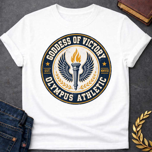 White T-shirt with an Official athletic seal in navy blue, cream, and gold featuring a torch with large outstretched wings symbolizing Nike, the goddess of victory. Flames burn from the torch. Olive wreaths frame either side. Text reads 'GODDESS OF VICTORY' and 'OLYMPUS ATHLETIC' around the circular border with 'EST. MMVIII.' Distressed vintage texture and gold stars enhance the emblem. Celebrates athletic achievement and triumph.
