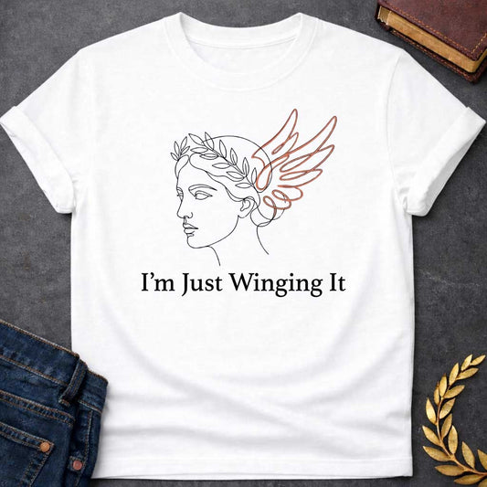 White T-shirt with a Minimalist line art illustration of a classical Greek profile with a laurel wreath crown and large terracotta-colored wings extending from the head. Elegant continuous line drawing style. Text reads 'I'm Just Winging It' in serif font below. References Nike, the goddess of victory, with a humorous modern spin. Blends classical mythology with relatable contemporary humor about improvisation and navigating life without a plan.