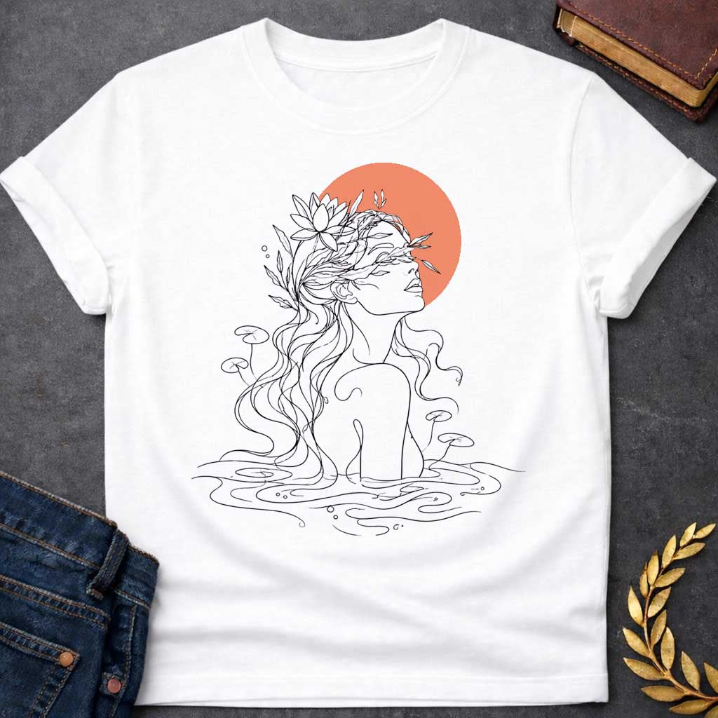 White T-shirt with a minimalist, single-line art illustration of a water nymph. The design features the profile of a woman emerging from a stylized pond, with flowing hair adorned with water lilies and aquatic plants. The sun is represented by a solid, warm terracotta circle behind her head. The graphic uses fine black lines on a clean background, creating a serene, modern, and nature-inspired aesthetic