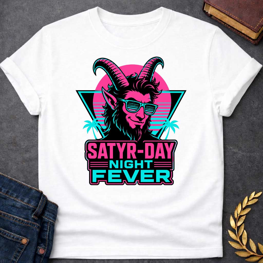 White T-shirt with a vibrant 1980s synthwave-style graphic for "satry-day night fever.jpg". It features a cool satyr with large horns, a smirk, and cyan shutter shades, illuminated in neon pink and black. The background shows a retrowave sunset grid, a black triangle, and palm trees. Below, the punny title "SATYR-DAY NIGHT FEVER" is displayed in bold neon pink and cyan block lettering against a dark badge