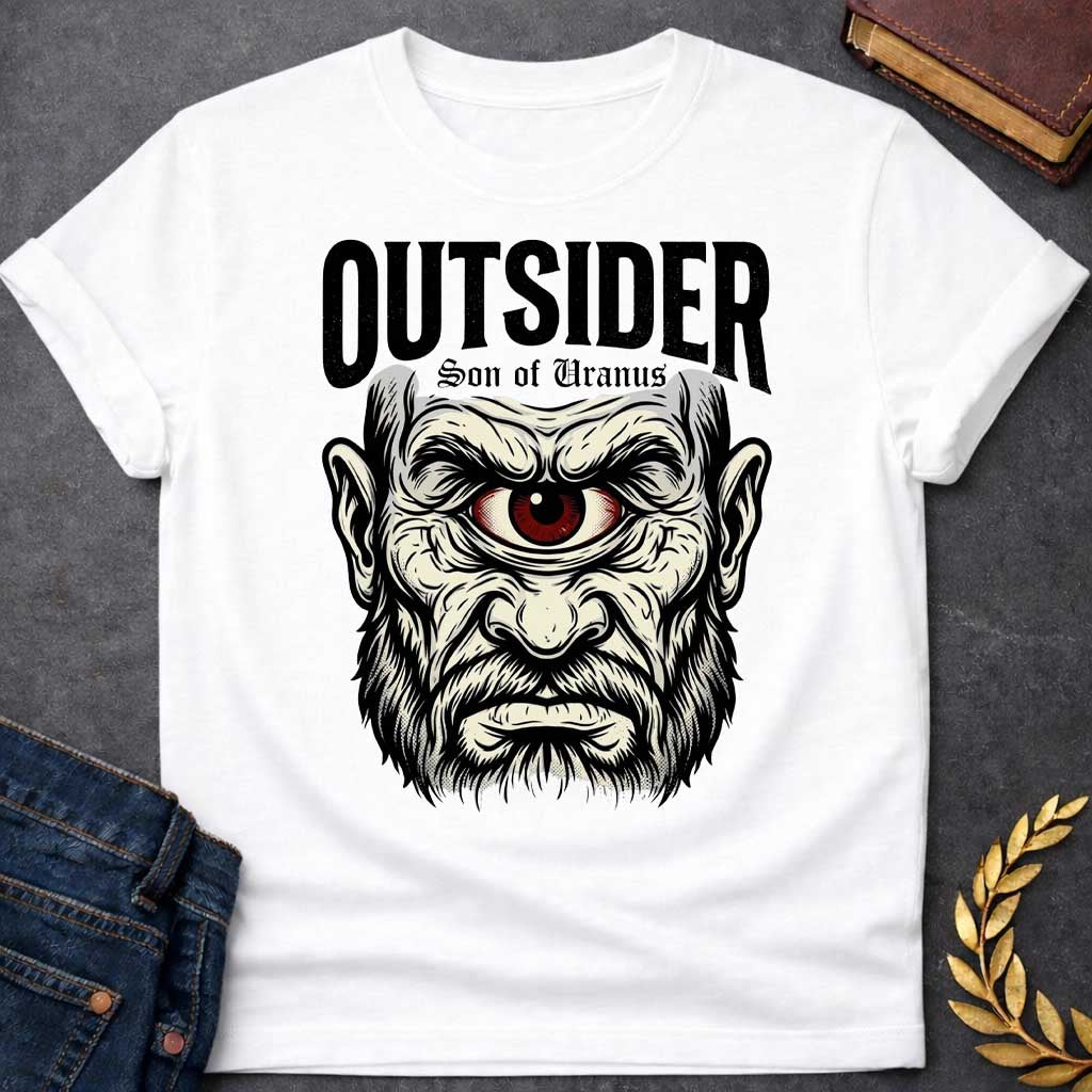 White T-shirt with a Bold typography design featuring a single-eyed Titan face with fierce expression. Thick white beard and long flowing hair frame a menacing red eye with intense gaze. Black and white engraving style with intricate line work emphasizing the character's otherworldly nature. Text reads 'OUTSIDER' and 'Son of Uranus' referencing the Titans of Greek mythology. Celebrates mythological outsider status, divine rebellion, and powerful, untamed forces beyond mortal comprehension.