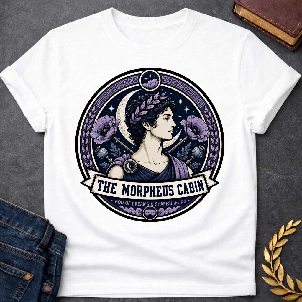 White t-shirt with a Morpheus Greek mythology cabin design featuring the god of dreams and shapeshifting in a navy and lavender circular emblem. Morpheus wears a laurel crown and classical robes, surrounded by a crescent moon, stars, purple poppies, poppy pods, clouds, and Greek key details. Text reads “The Morpheus Cabin” and “God of Dreams & Shapeshifting,”