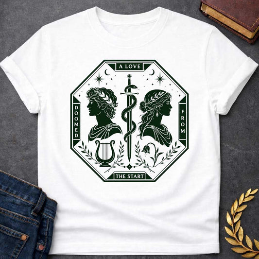 White t-shirt in dark green tarot-card style: an octagonal frame shows two facing silhouette profiles (a laurel-crowned man and a woman with a headband) separated by a snake-entwined sword. Below them sit a lyre and a drooping flower, framed by olive branches, stars, and crescent moons, evoking Orpheus and Eurydice.