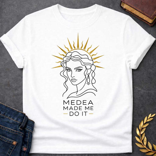 White T-shirt with a Minimalist line art portrait of Medea with wavy hair and drop earrings, framed by a golden radiating sun halo. Black and white design with gold accents. Text reads 'Medea Made Me Do It.' Humorous reference to blaming the legendary Greek sorceress for chaotic or destructive actions. Celebrates Medea's infamous power and magical influence with tongue-in-cheek blame attribution.