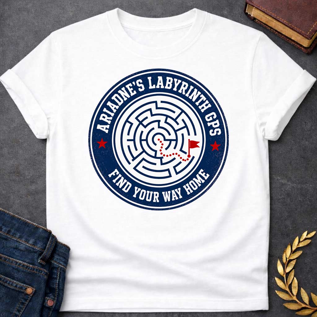 White T-shirt with A Circular emblem with concentric maze in navy and white, featuring a red dotted path through the labyrinth toward a flag marker. Red stars accent the design. Text reads 'Ariadne's Labyrinth GPS' around the border and 'Find Your Way Home' below. Merges Greek mythology with modern GPS technology, presenting the legendary thread as contemporary guidance. Celebrates finding home through challenging mazes.

