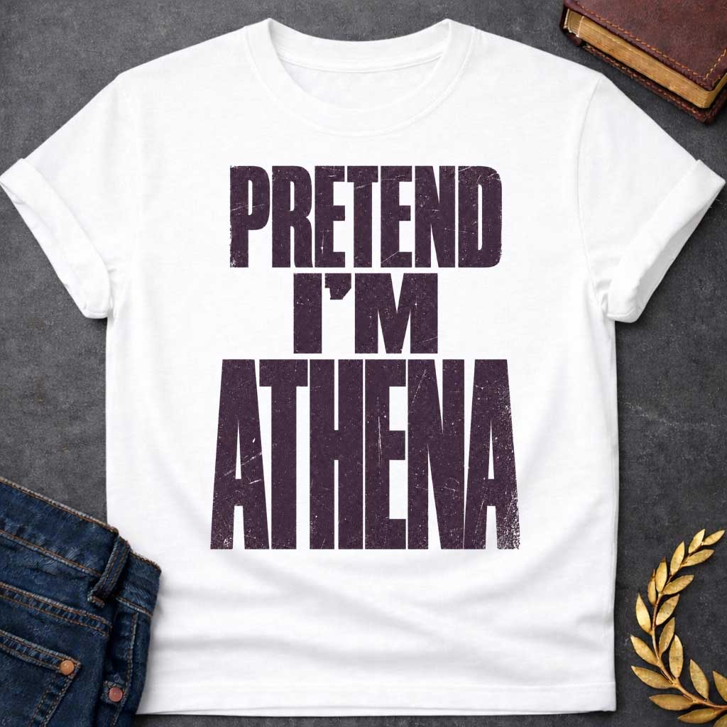 White t-shirt with a Pretend I’m Athena Greek mythology design featuring bold distressed purple typography on a transparent background. The stacked text reads “PRETEND I’M ATHENA” in a rugged vintage block font, creating a humorous design inspired by Athena, the Greek goddess of wisdom, warfare, strategy, and crafts.