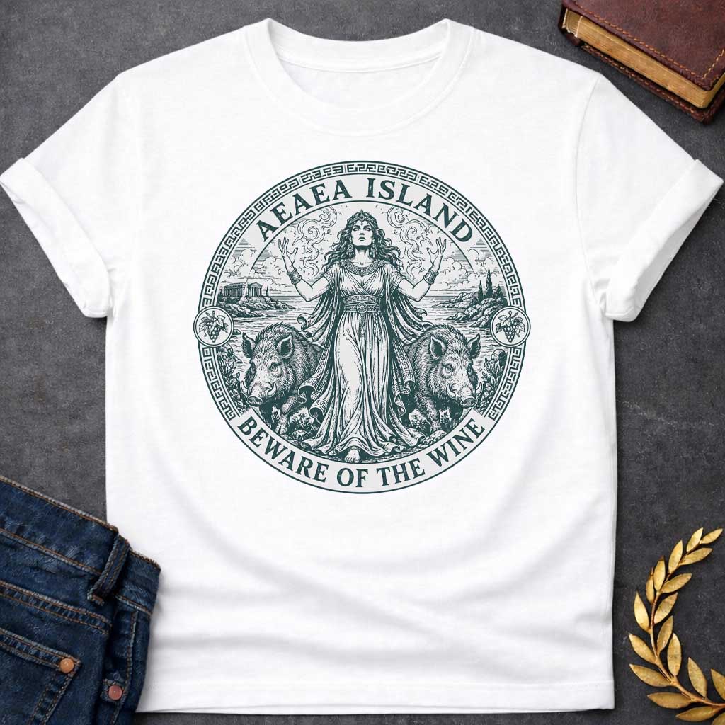 White T-shirt with a Classical engraving-style illustration of Circe, the Greek goddess of magic, commanding her island of Aeaea with raised arms and mystical power. She wears an ornate crown and flowing draped robes adorned with jewelry. Two human-headed pigs flank her, representing men transformed through her enchanted wine. Grape vines with fruit surround the mystical coastal scene. Greek key pattern border in teal frames the circular composition. Text reads 'Aeaea Island' and 'Beware of the Wine.' Celeb