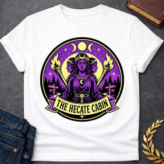 White t-shirt with a Hecate Greek mythology design featuring the triple goddess with three faces, crescent moon symbols, glowing torches, stars, and a mystical purple night sky. Forest silhouettes and crossroads signs represent Hecate’s connection to magic and crossroads, framed in a circular camp-style emblem with the text “The Hecate Cabin.”