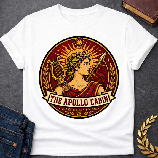 White t-shirt with a Apollo Greek mythology cabin design featuring the god of the sun and music wearing a golden laurel crown, framed by a radiant sun, lyre, spear, stars, and laurel branches. Rich red, gold, and cream circular camp-style emblem includes the text “The Apollo Cabin” and “God of the Sun & Music.
